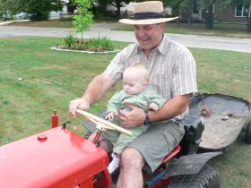 Aug 9/07 - Isabel riding on Grandpa's tractor